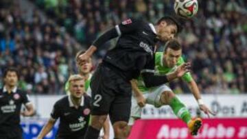 El defensa chileno del Mainz 05, Gonzalo Jara (C ) disputa el bal&oacute;n con el jugador del Wolfsburgo Ivan Perisic.
 