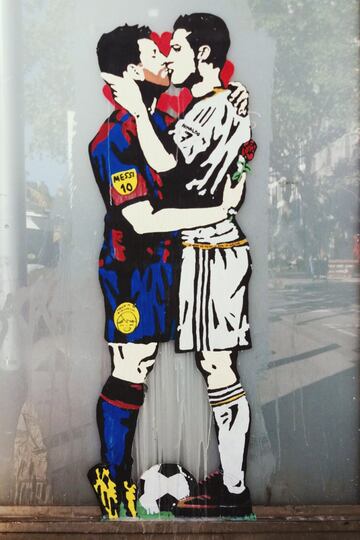 Son c¨¦lebres las parejas futboleras nacidas bajo el spray de TVBoy, pero hay una cuya fama dio la vuelta al mundo, la formada por Messi y Cristiano. Archienemigos en lo deportivo, pero bes¨¢ndose apasionadamente en este graffiti. La obra, ubicada en el paseo de Gr¨¤cia, apareci¨® en v¨ªsperas de Sant Jordi y, adem¨¢s, previa del Cl¨¢sico. De ah¨ª que esta imagen se hiciera viral y su autor saltara al estrellato. ¡®Love is blind¡¯ tiene un claro mensaje: ¡°No hay que tomarse el f¨²tbol tan en serio, hay que disfrutarlo¡±. Con esa intenci¨®n e id¨¦ntica f¨®rmula uni¨® a Pique con Ramos y a Guardiola con Mourinho, dejando atr¨¢s sus rencillas y en actitud cari?osa.