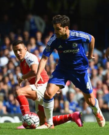 Alexis Sanchez intenta frenar a Cesc Fabregas en el derbi londinense.