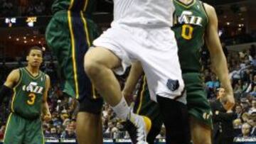 Derrick Favors (i) y Enes Kanter de los Jazz intentan bloquear la entrada a canasta de Marc Gasol