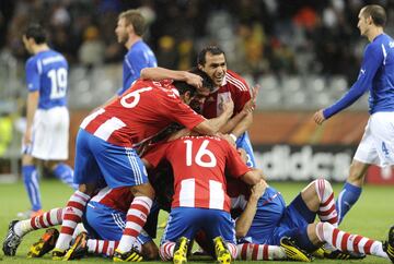 Antolín Alcaraz es rodeado por todos sus compañeros. Paraguay acaba de sorprender a Italia... con una jugada de estrategia: una falta lateral a la que De Rossi no es capaz de llegar dejando el remate franco del defensor paraguayo. Cannavaro tampoco sabe reaccionar: le había dejado un metro de distancia al zaguero albirrojo...