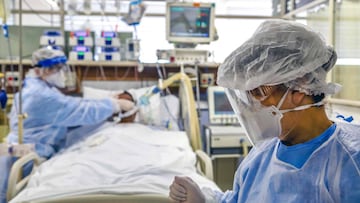 Imagen de dos profesionales sanitarios atendiendo a un paciente de coronavirus en un hospital.