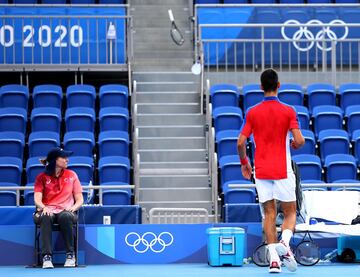 Novak Djokovic observa su raqueta que lanzó con rabia a la grada.