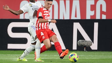 Girona's Spanish defender Arnau Martinez (R) vies with Real Madrid's Brazilian forward Vinicius Junior during the Spanish league football match between Girona FC and Real Madrid CF at the Montilivi stadium in Girona on April 25, 2023. (Photo by LLUIS GENE / AFP)