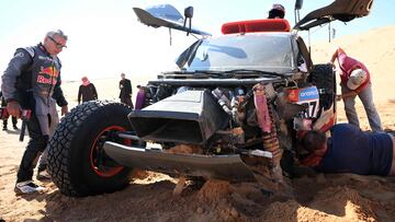 El piloto de Audi Carlos Sainz revisando los daños del coche después de su accidente en la sexta etapa del Dakar.