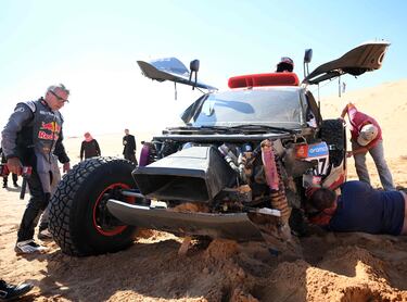 El piloto de Audi Carlos Sainz revisando los daños del coche después de su accidente en la sexta etapa del Dakar.