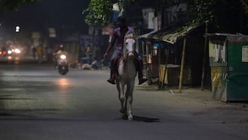 A man rides a horse along a semi-deserted street in Siliguri on April 7, 2020. 