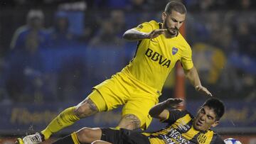 Boca Juniors' forward Dario Benedetto (L) is fouled by Olimpo's defender Cristian Villanueva during their Argentina First Division Superliga football match at La Bombonera stadium, in Buenos Aires, on August 27, 2017. / AFP PHOTO / ALEJANDRO PAGNI