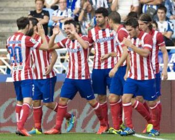 El delantero del Atlético de Madrid David Villa celebra con sus compañeros la consecución del primer gol de su equipo ante la Real Sociedad, durante el partido de la tercera jornada de liga en Primera División que se disputa esta tarde en el estadio Anoeta de San Sebastián.