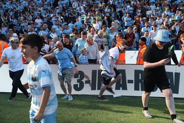 Los seguidores del Manchester City invaden el campo durante las celebración por el título después del partido de fútbol de la Premier League inglesa contra el Chelsea.