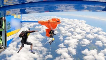 Paracaidista salta de un avión en el que otro paracaidista está enganchado en el ala trasera