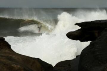 Esta imagen del surfista australiano Russell Bierke durante una competici車n en Sydney muestra el riesgo que tiene este deporte. Apenas se le ve entre las olas y da la sensaci車n que est芍 muy cerca de las rocas.