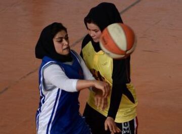 Las jugadoras de baloncesto afganas de la provincia de Herat (en amarillo) compiten con el equipo de Kabul, en un partido amistoso en el Estadio Olímpico Nacional de Kabul el 18 de septiembre de 2013.