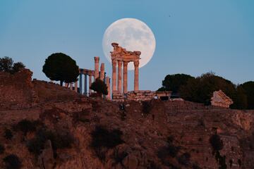 La luna llena sale detrás de la antigua ciudad de la Acrópolis en el distrito de Bergama de Izmir, Turquía.