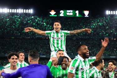 Los jugadores y aficionados del Betis, celebran la victoria ante el Sevilla tras finalizar el partido en el estadio Benito Villamarín.