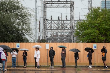 Los votantes esperan en fila bajo una intensa lluvia en el Centro Multiservicios West Gray de Houston.