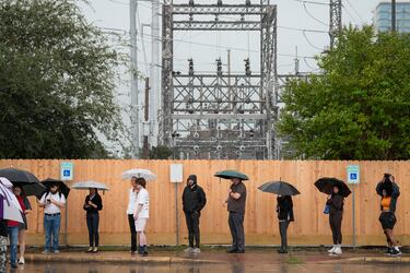 Los votantes esperan en fila bajo una intensa lluvia en el Centro Multiservicios West Gray de Houston.