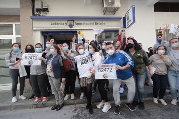 Varias personas celebran el tercer premio, el número 52472, en la localidad gaditana de Barbate. Esta administración, la número 2, ha repartido 45 millones de euros.