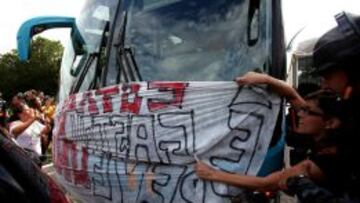 Dos mujeres colocan un cartel durante una protesta de maestros de Río hoy, lunes 26 de mayo de 2014, durante la llegada de la selección brasileña de fútbol.