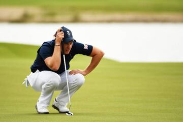 Danny Willett of Great Britain lines up a putt on the third green.