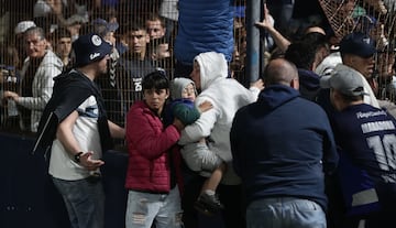 Fans react after police fired tear gas and entered the Juan Carmelo Zerillo stadium during the match between Gimnasia and Boca Juniors in La Plata, Argentina on October 6, 2022.