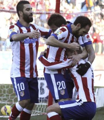 El delantero francés del Atlético de Madrid Antoine Griezmann celebra con sus compañeros, el centrocampista turco Arda Turan y el defensa Juafran Torres, el gol que acaba de marcar, el primero de su equipo frente al Levante, durante el partido de la decimoséptima jornada de Liga de Primera División.