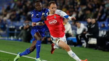 GETAFE (MADRID), 09/12/2024.- El delantero del Espanyol Irvin Cardona (d) pelea un balón con Djené Dakoman, del Getafe, durante el partido de LaLiga EA Sports que Getafe CF y RCD Espanyol disputan hoy lunes en el Coliseum de Getafe. EFE/Juanjo Martín