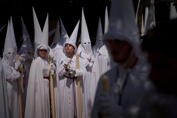 Penitentes de la Hermandad de la Paz participan en una procesión el Domingo de Ramos en Sevilla.