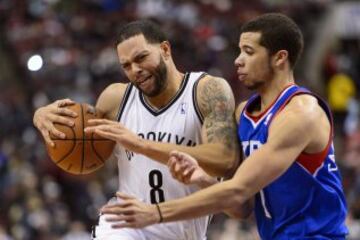 Deron Williams (8) es defendido por Michael Carter-Williams (1).