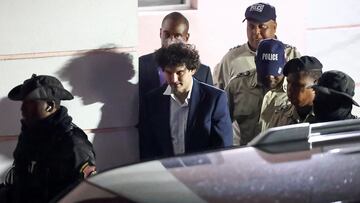 Sam Bankman-Fried, who founded and led FTX until a liquidity crunch forced the cryptocurrency exchange to declare bankruptcy, is escorted out of the Magistrate Court building after his arrest in Nassau, Bahamas.