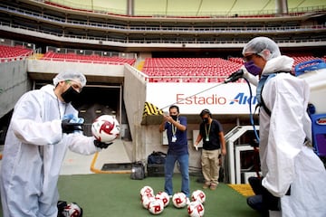 Dos operarios desinfectan los balones antes del partido de fútbol que enfrentó al Atlas y a los Tigres, correspondiente a los cuartos de final de la Copa de México, disputado en el Estadio Akron de Guadalajara. El empate a dos goles clasificó a los Tigres, que ahora se enfrentarán al Cruz Azul en las semifinales.