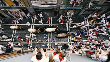 Participantes corren delante de los toros durante el primer encierro de los Sanfermines en Pamplona.