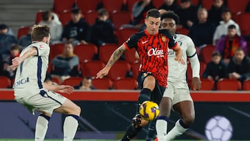 PALMA DE MALLORCA, 10/02/2025.- El centrocampista del Mallorca Dani Rodríguez (c) controla un balón ante Boyomo (d), de Osasuna, en el partido de LaLiga entre el Mallorca y el Osasuna, este lunes en el estadio de Son Moix, en Palma. EFE/CATI CLADERA