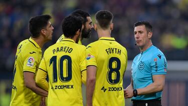 Los jugadores del Villarreal protestan a Soto Grado el penalti por mano de Foyth.