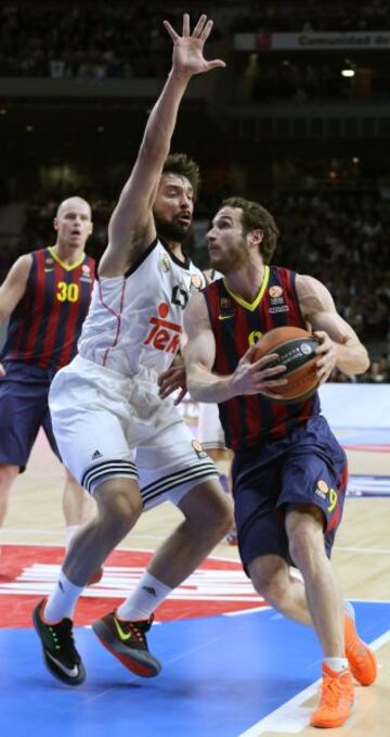 El base italiano del FC Barcelona Marcelinho Huertas, centra a canasta ante el base del Real Madrid Sergio Llull durante el partido del Top-16 de la Euroliga, Grupo E, disputado esta tarde en el Palacio de los Deportes de la Comunidad de Madrid. 
