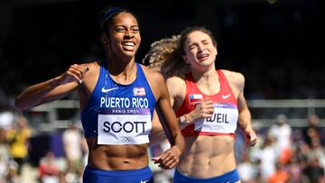 Puerto Rico's Gabby Scott and Chile's Martina Weil cross the finish line in the women's 400m repechage round of the athletics event at the Paris 2024 Olympic Games at Stade de France in Saint-Denis, north of Paris, on August 6, 2024. (Photo by Jewel SAMAD / AFP)