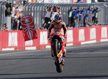 El piloto de Repsol Honda, Marc Márquez, realizando un caballito al cruzar la línea de meta. 