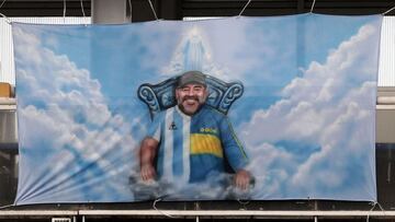 (FILES) In this file photo taken on March 14, 2021 a banner with an image of late Argentine football icon Diego Maradona is seen during the Argentine Professional Football League Superclasico match between Boca Juniors and River Plate at La Bombonera stadium in Buenos Aires. - The public prosecutor&#039;s office investigating Argentine football star Diego Maradona&#039;s death postponed on May 28, 2021 for June 14 the beginning of the hearings of seven people suspicious of having &quot;abandoned him to his fate&quot;, which were scheduled to start on May 31. (Photo by Alejandro PAGNI / POOL / AFP)