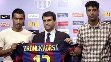 El defensa holand&eacute;s, Giovanni van Bronckhorst (i) y el presidente del F.C.Barcelona, Joan Laporta (c), junto el entrenador del Barcelona Rijkaard,durante la presentaci&oacute;n del nuevo jugador azulgrana para la pr&oacute;xima temporada.