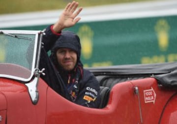 Red Bull Racing driver Sebastian Vettel of Germany arrives on a classic car during a drivers parade ahead of the Formula One Japanese Grand Prix in Suzuka on October 5, 2014. AFP PHOTO/ TOSHIFUMI KITAMURA