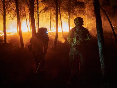Dos bomberos trabajan para impedir que el incendio se propague en Carcastillo, Navarra (España).