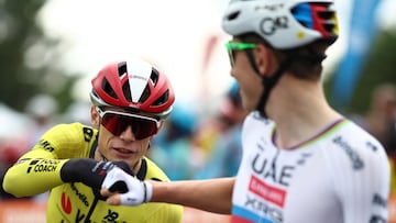 UAE Team Emirates' Slovenian rider Tadej Pogacar (R) fist bumps with Team Visma-Lease a Bike's Danish rider Jonas Vingegaard prior to the start of the 1st stage of the 77th edition of the Criterium du Dauphine cycling race, 195,8 km between Dom�rat and Montlucon, on June 8, 2025. (Photo by Anne-Christine POUJOULAT / AFP)