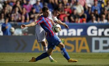 El delantero colombiano del Real Madrid, James Rodríguez (detrás), pelea un balón con el defensa del Levante UD Iván López.