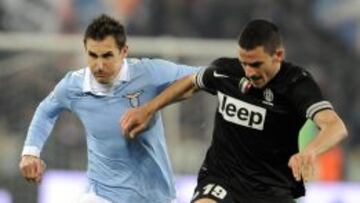 El jugador de Lazio Miroslav Klose disputa el balón con Leonardo Bonucci de Juventus hoy, martes 29 de enero de 2013, durante la semifinal de la Copa Italia que se disputa en el estadio Olímpico de Roma, Italia.