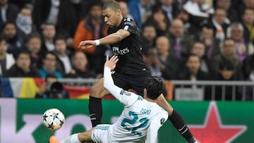 Paris Saint-Germain's French forward Kylian Mbappe (L) vies with Real Madrid's Spanish midfielder Isco (R) during the UEFA Champions League round of sixteen first leg football match Real Madrid CF against Paris Saint-Germain (PSG) at the Santiago Bernabeu stadium in Madrid on February 14, 2018. / AFP PHOTO / GABRIEL BOUYS