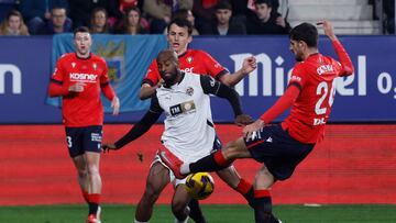 PAMPLONA, 02/03/2025.- El defensa del Osasuna Alejandro Catena (d) disputa un balón con el defensa del Valencia Dimitri Foulquier (c) durante el partido de LaLiga EA Sports entre CA Osasuna y Valencia CF, este domingo en el Estadio El Sadar de Pamlona. EFE/ Villar López