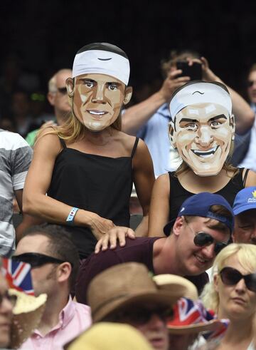 Dos mujeres con caretas de Rafa Nadal y Roger Federer durante un encuentro de cuarta ronda del torneo de Wimbledon.