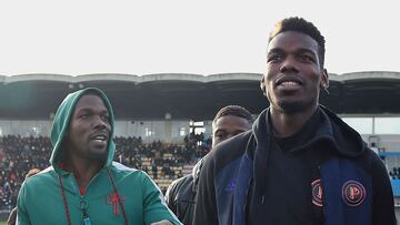 (FILES) This file photo taken on December 29, 2019 shows France national team player Paul Pogba (R) and his brother Mathias Pogba (L) walking on the pitch prior to a football match between All Star France and Guinea at the Vallee du Cher Stadium in Tours, central France, as part of the "48h for Guinea" charity event. - Mathias Pogba, the elder brother of the footballer Paul Pogba, and three other people have been placed in custody in the investigation of extortion denounced by the player of Juventus Turin, it was learned on September 14, 2022 from judicial sources and close to the case. (Photo by GUILLAUME SOUVANT / AFP)