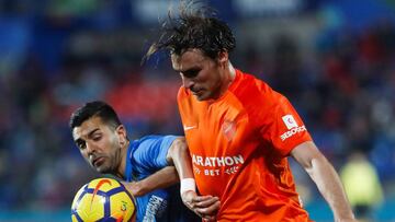 GRAF1020. GETAFE (MADRID), 12/01/2018.- El centrocampista del Getafe &Aacute;ngel Rodr&iacute;guez (i) pelea un bal&oacute;n con Ignasi Miquel, del M&aacute;laga, durante el partido de Liga en Primera Divisi&oacute;n disputado esta noche en el Coliseum Al