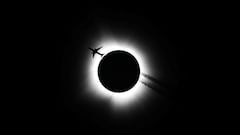 An airplane passes near the total solar eclipse during the Hoosier Cosmic Celebration at Memorial Stadium in Bloomington, Indiana, U.S. April 8, 2024. Bobby Goddin/USA Today Network via REUTERS NO RESALES. NO ARCHIVES. MANDATORY CREDIT